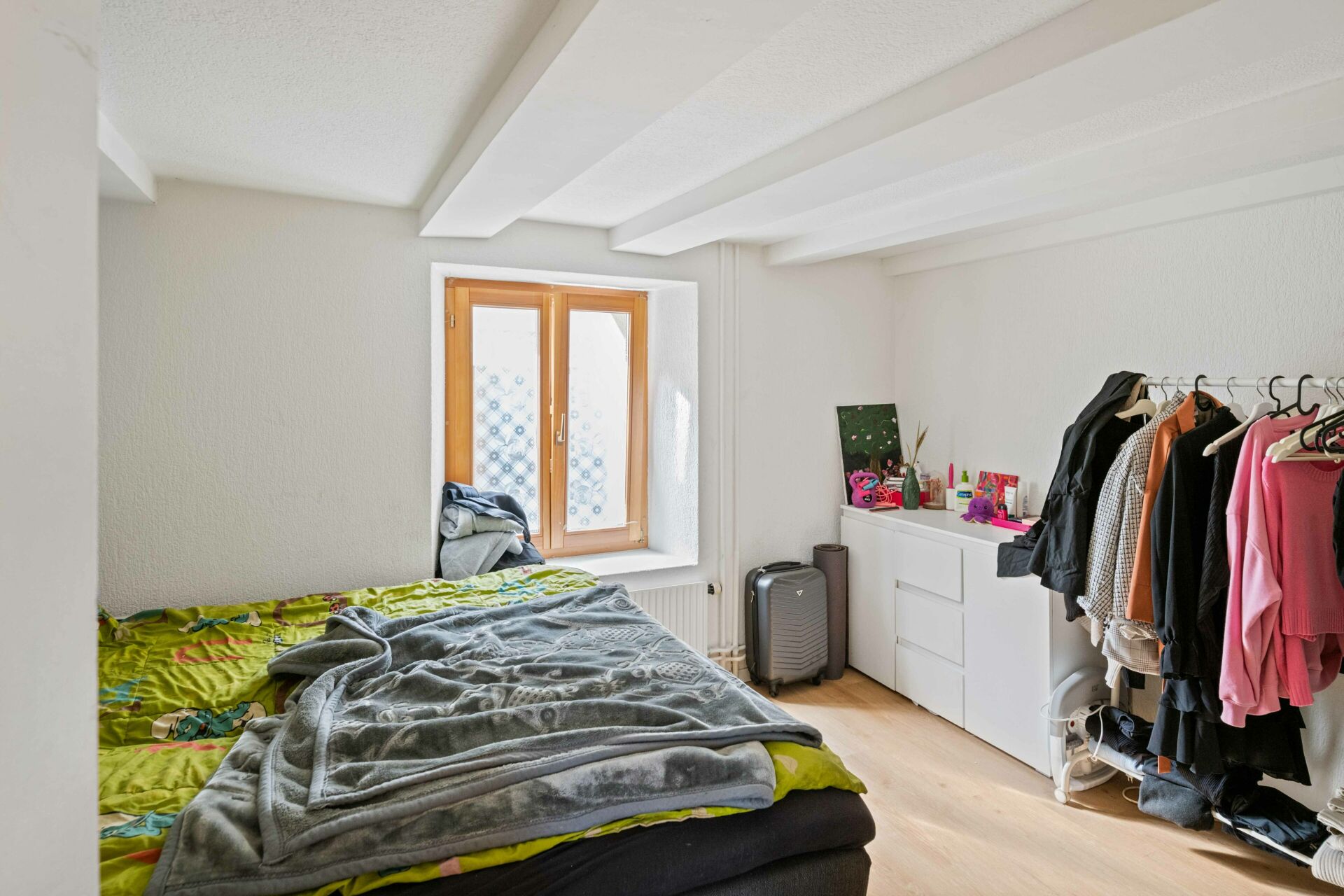 Schlafzimmer mit Kleidung und Fenster