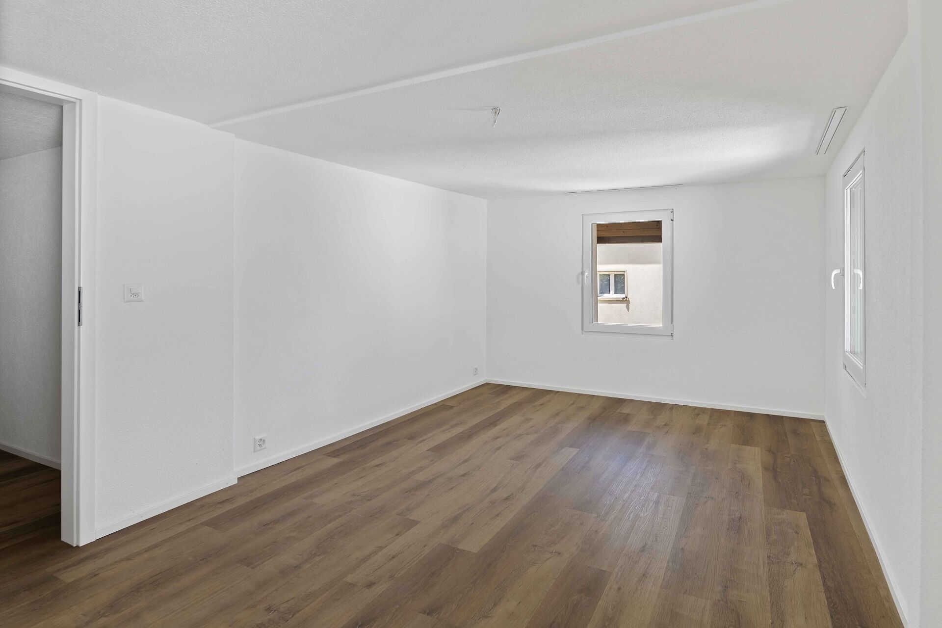 Leerer, heller Raum mit Holzoptikboden