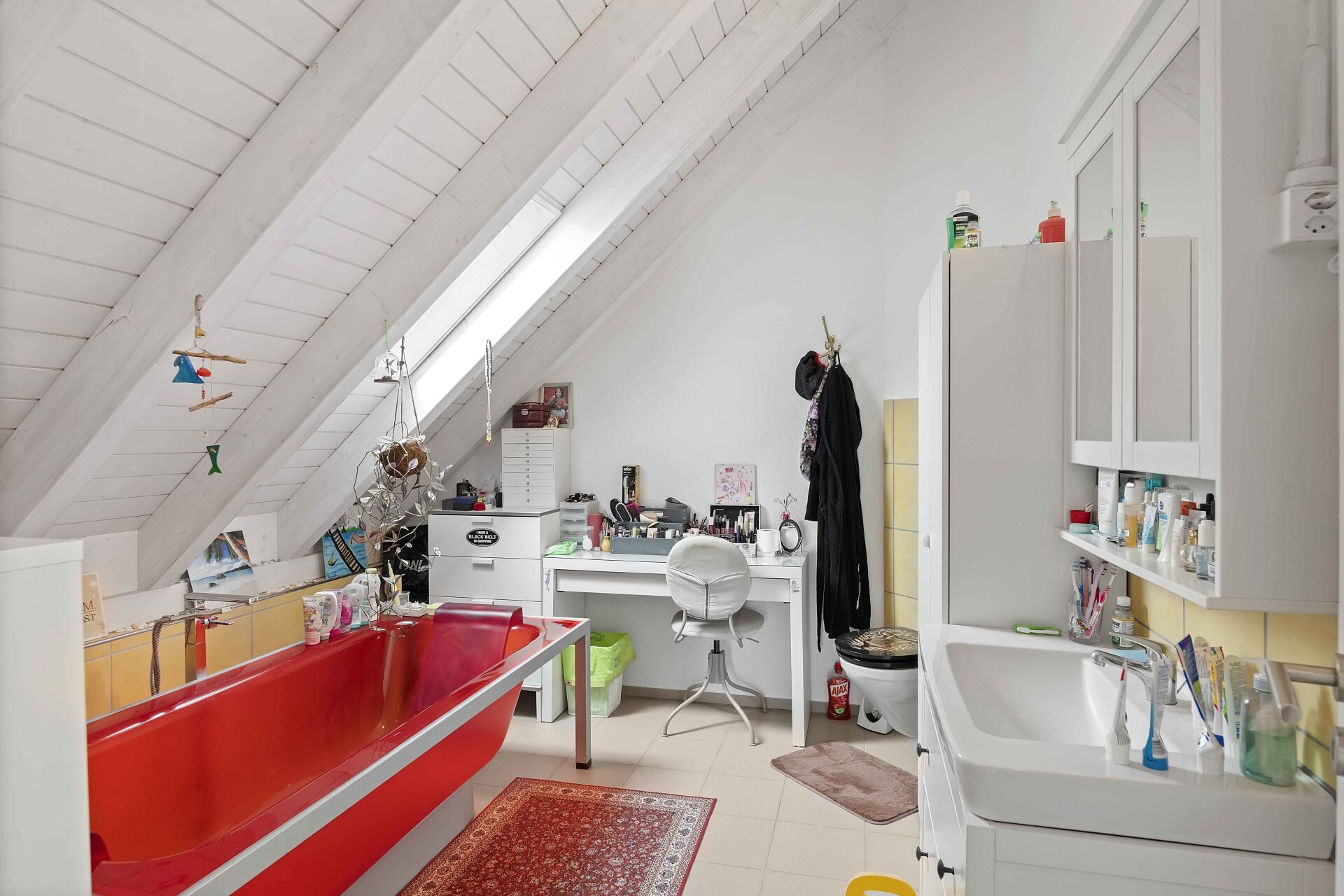 Badezimmer im Dachgeschoss mit roten Badewannelementen