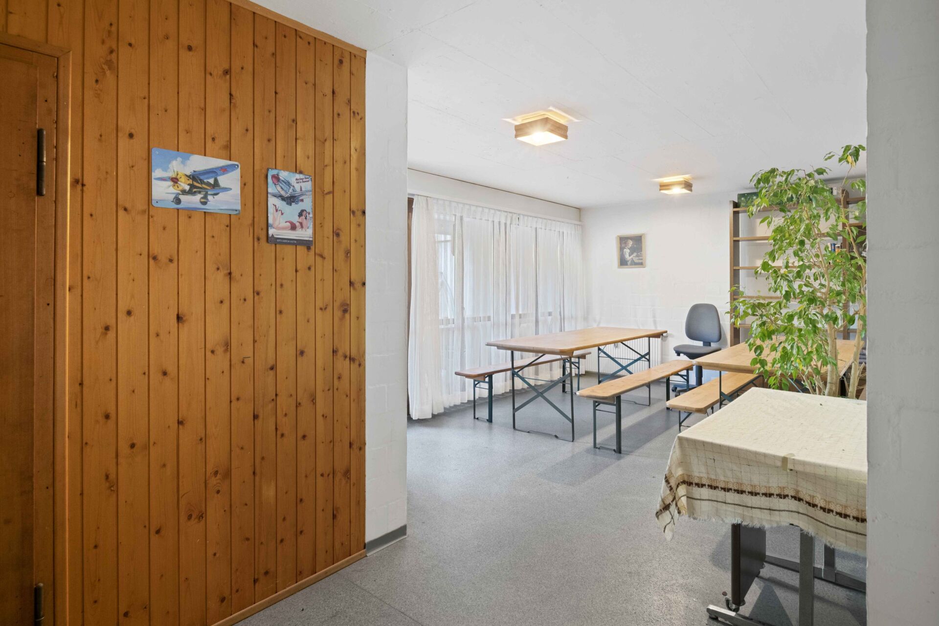 Heller Mehrzweckraum mit Holzverkleidung und Sitzmöbeln