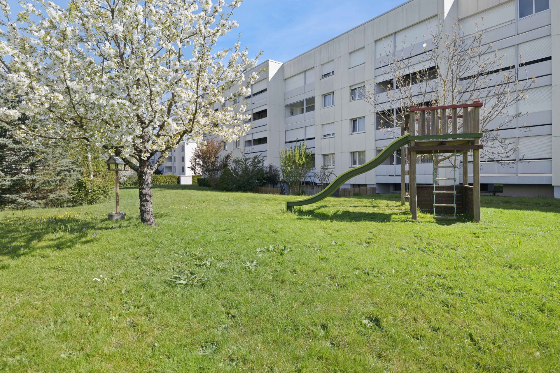 Außenansicht mit Garten und Spielplatz