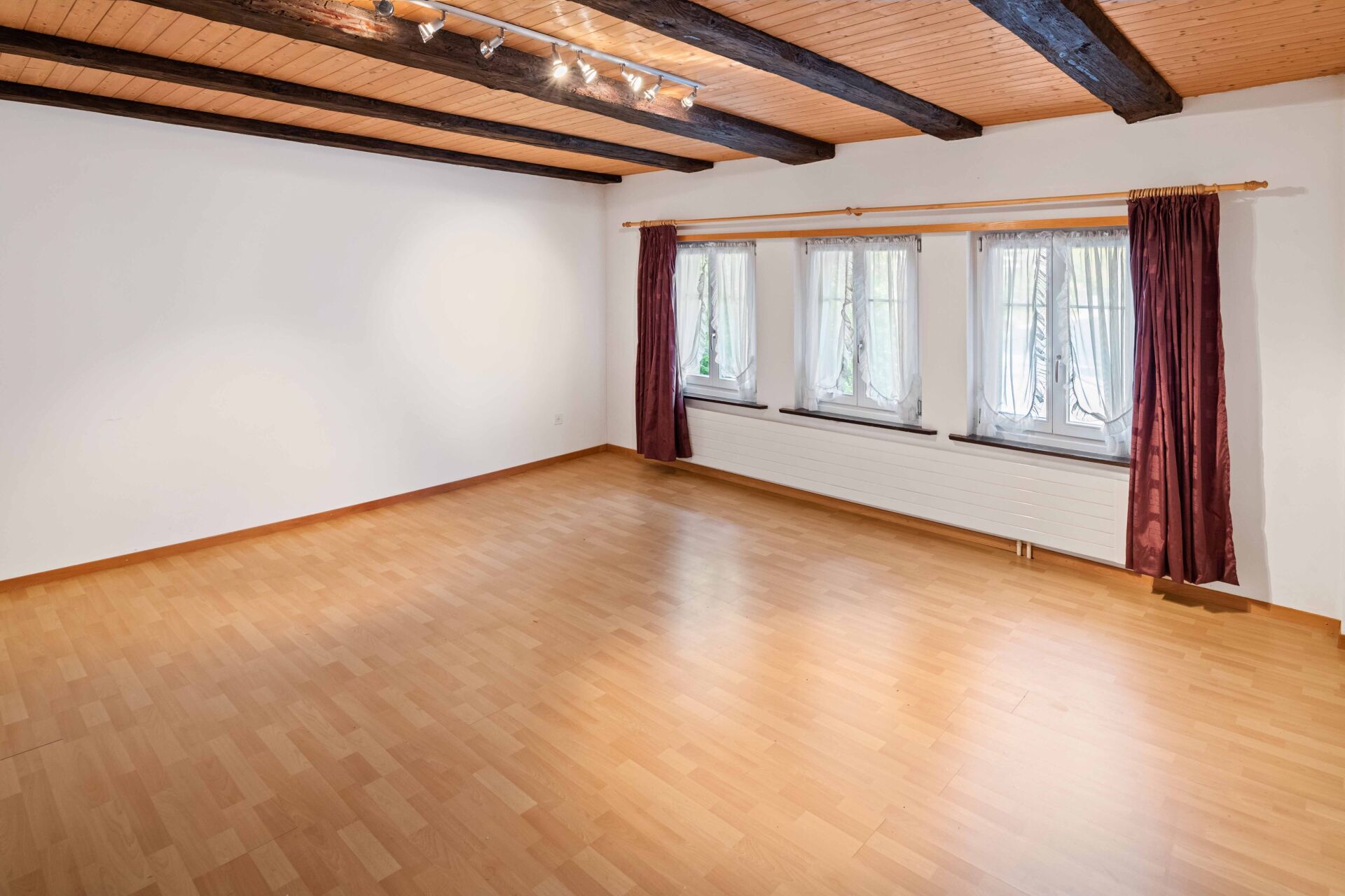 Leerer Wohnraum mit Holzbalkendecke