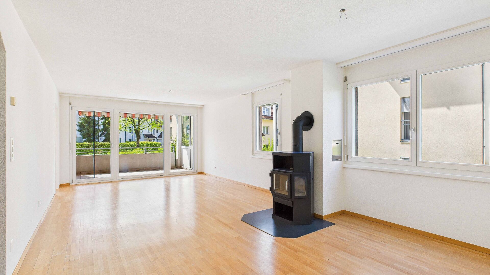 Heller Wohnraum mit Kamin und Balkonzugang