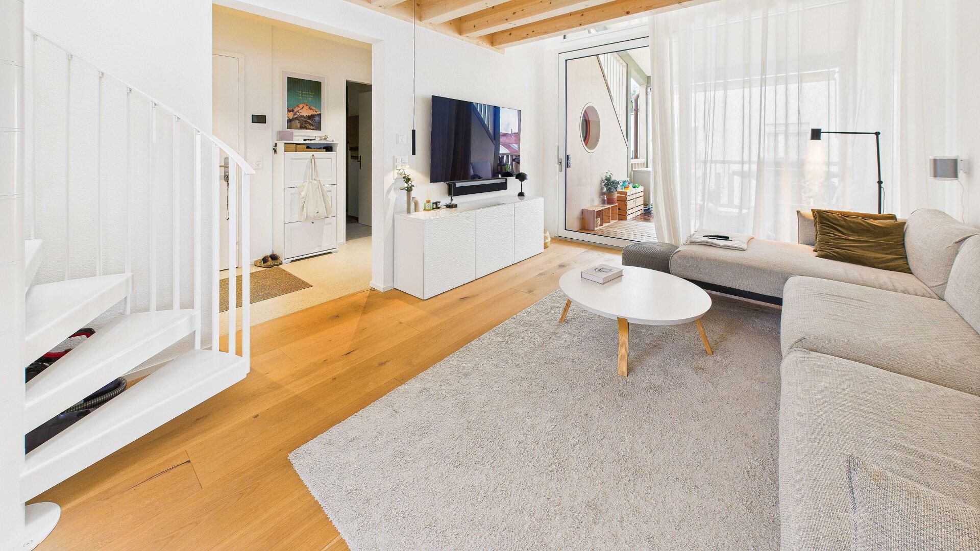 Heller, moderner Wohnbereich mit Treppe und Balkonzugang