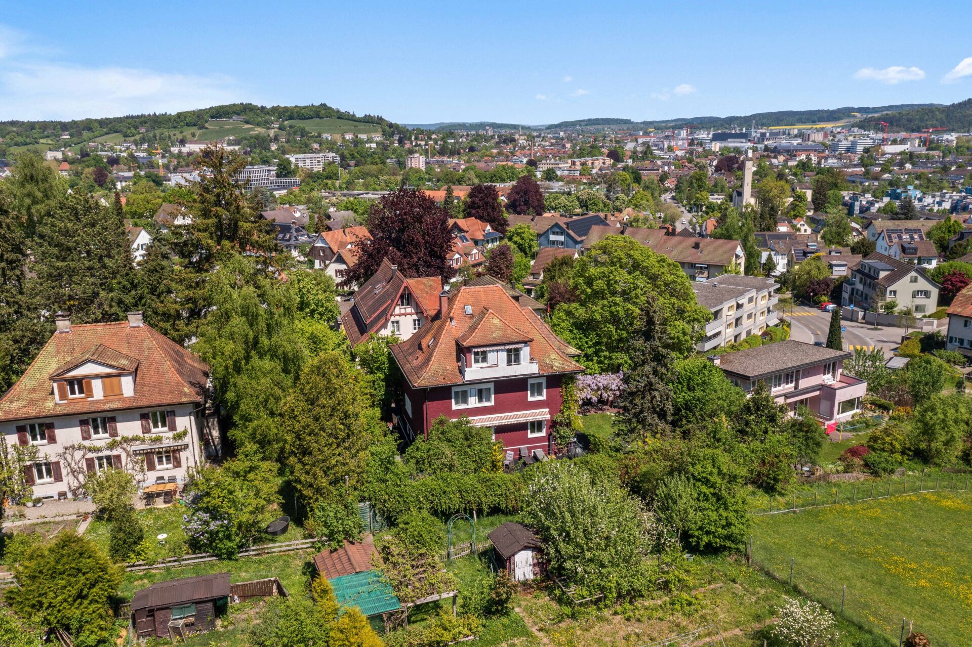 Städtische Wohngegend mit grüner Hügellandschaft