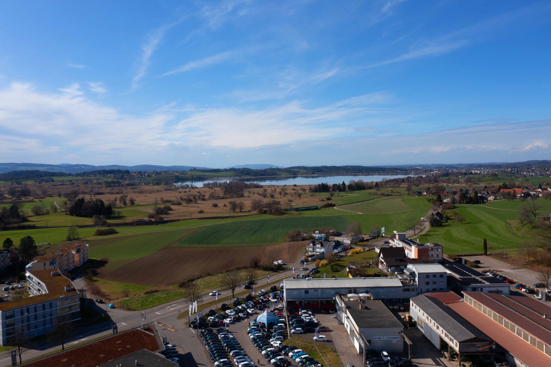 Landschafts- und Luftaufnahme mit See und Feldern