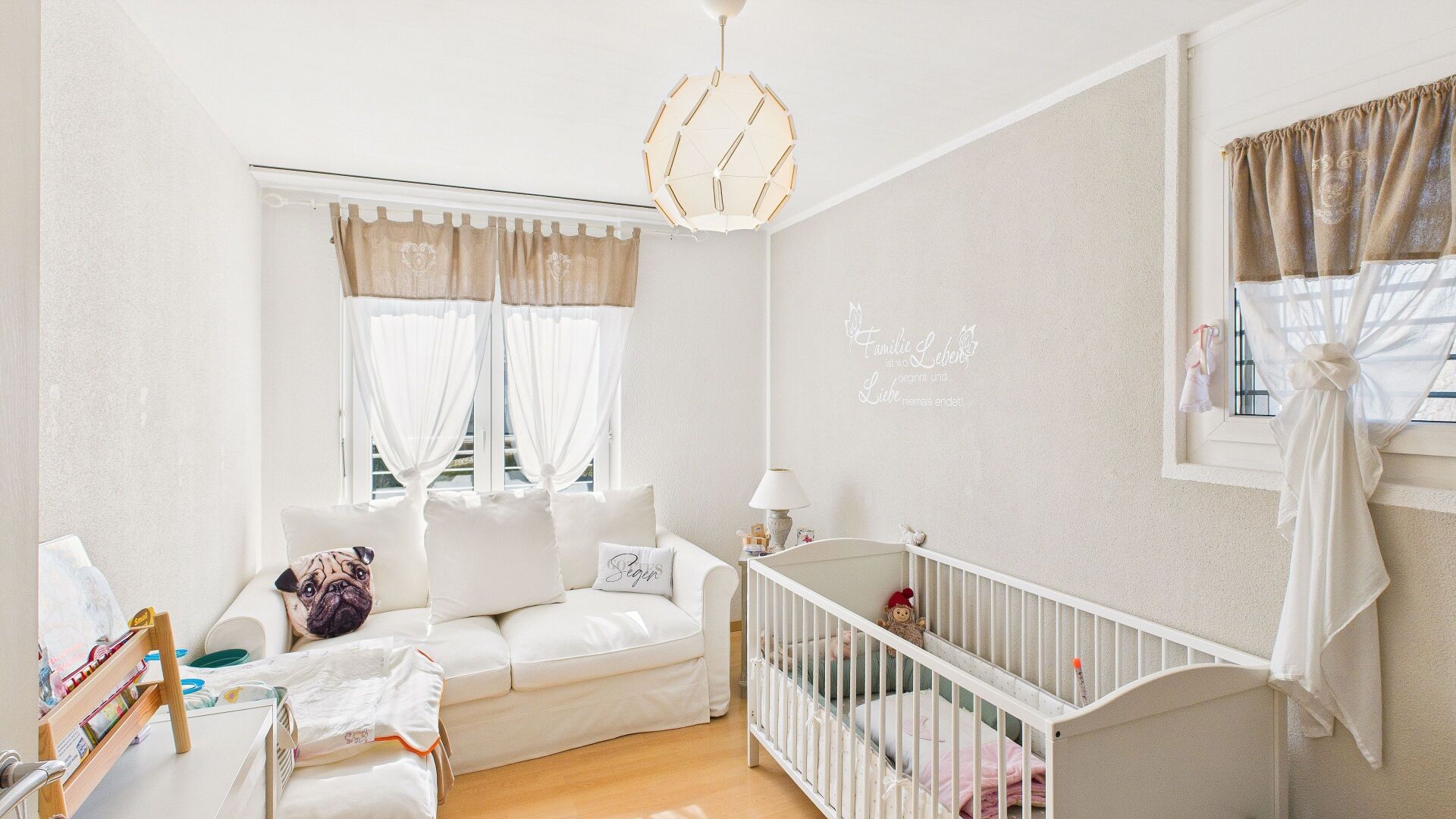 Helles Kinderzimmer mit Sofa und Babybett