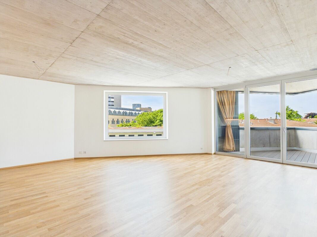 Großer leerer Wohnraum mit Balkon und Ausblick