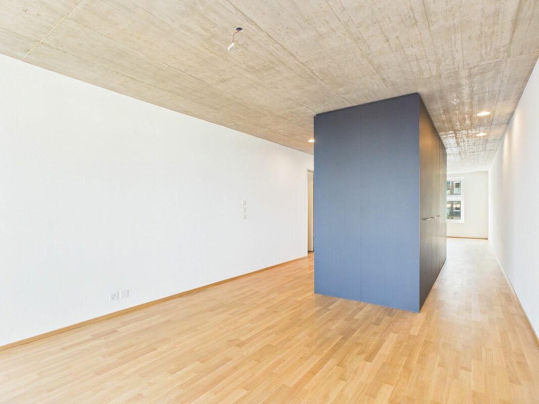 Moderner Flur mit Sichtbetondecke und blauem Einbaukubus