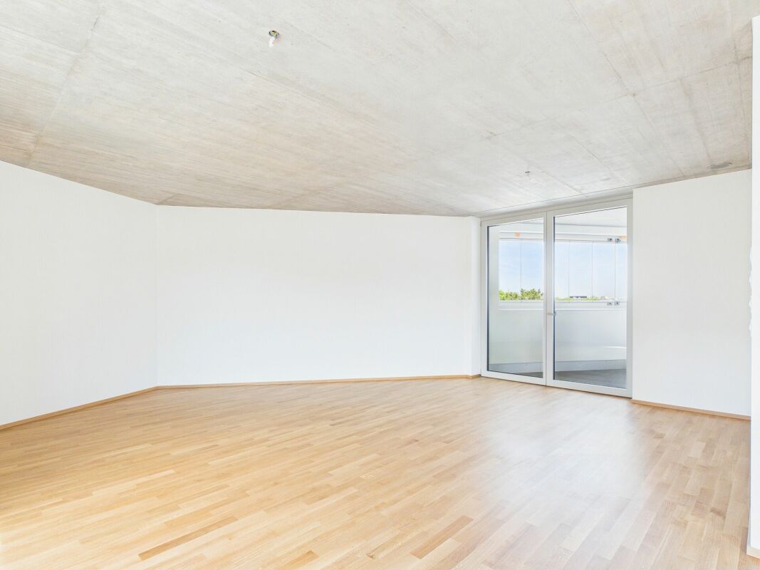 Leerer moderner Wohnraum mit Balkonzugang