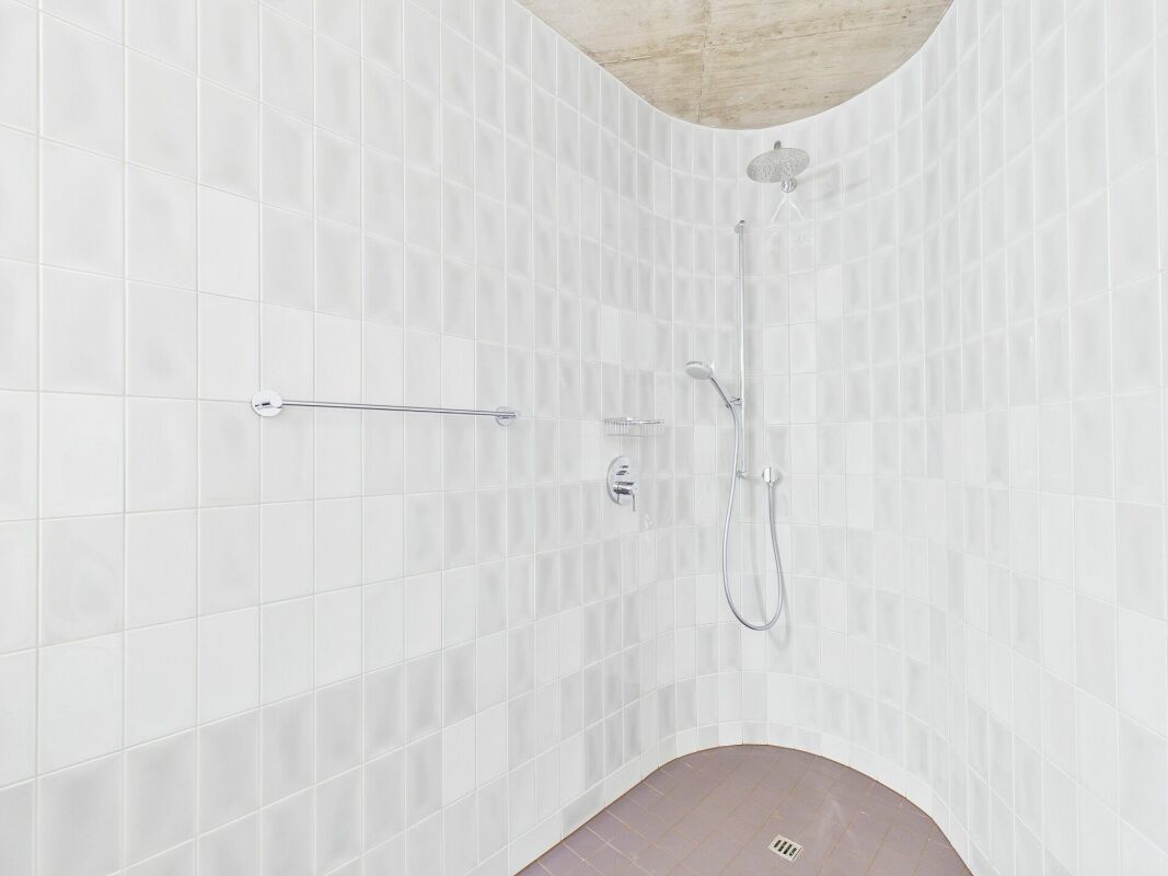 Runde Dusche mit weißen Fliesen