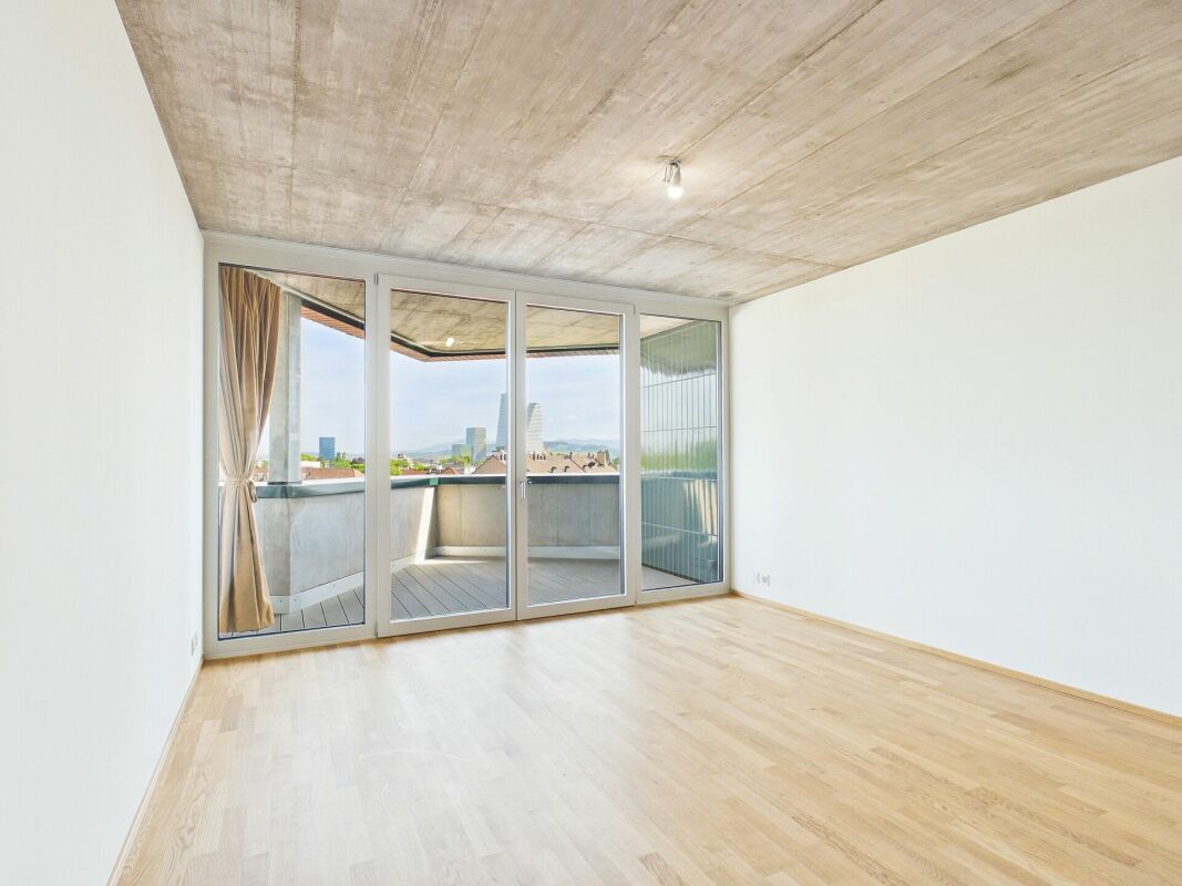 Leerer Wohnraum mit Balkon und Stadtblick