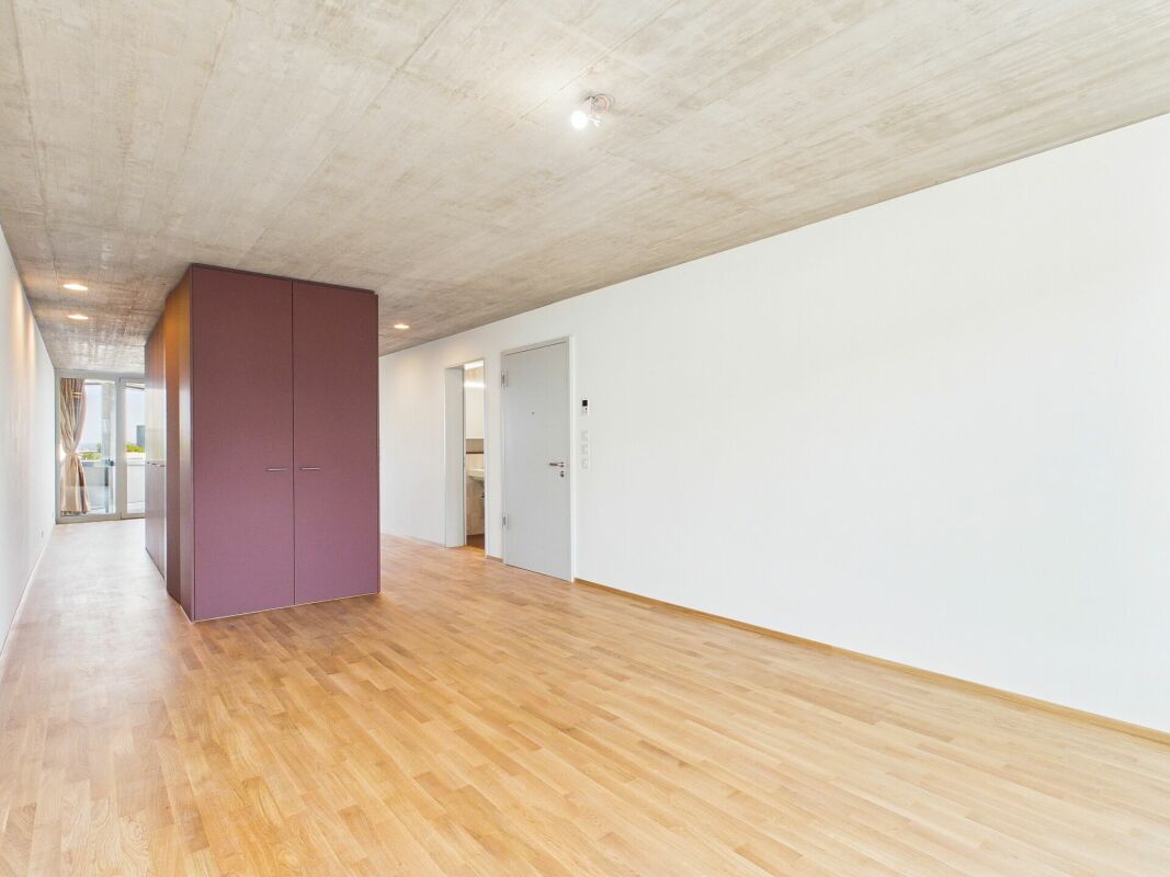 Langer Flur mit Beton-Decke und Holzfußboden