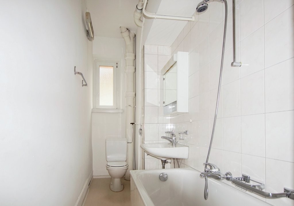 Schmales Badezimmer mit Badewanne und WC