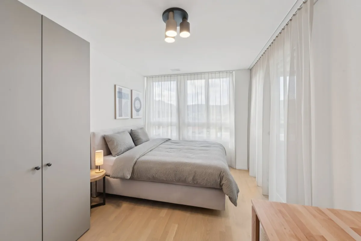 Helles, minimalistisches Schlafzimmer mit großem Fensterband