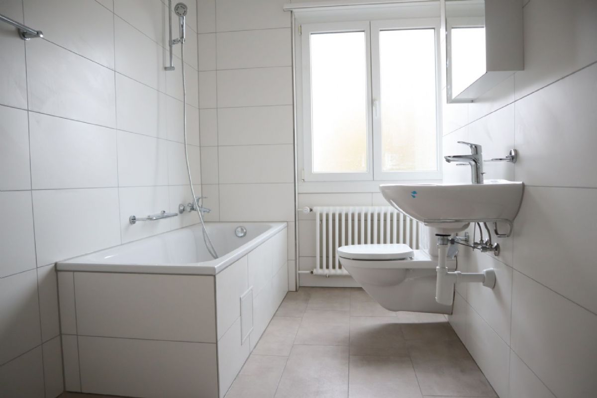 Helles Badezimmer mit Badewanne, WC und Waschbecken