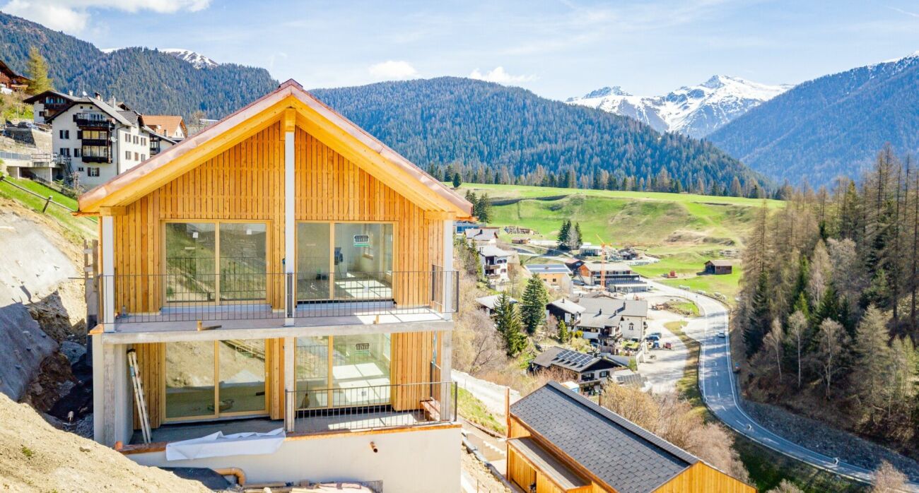 Alpenhaus im Bau mit Bergpanorama