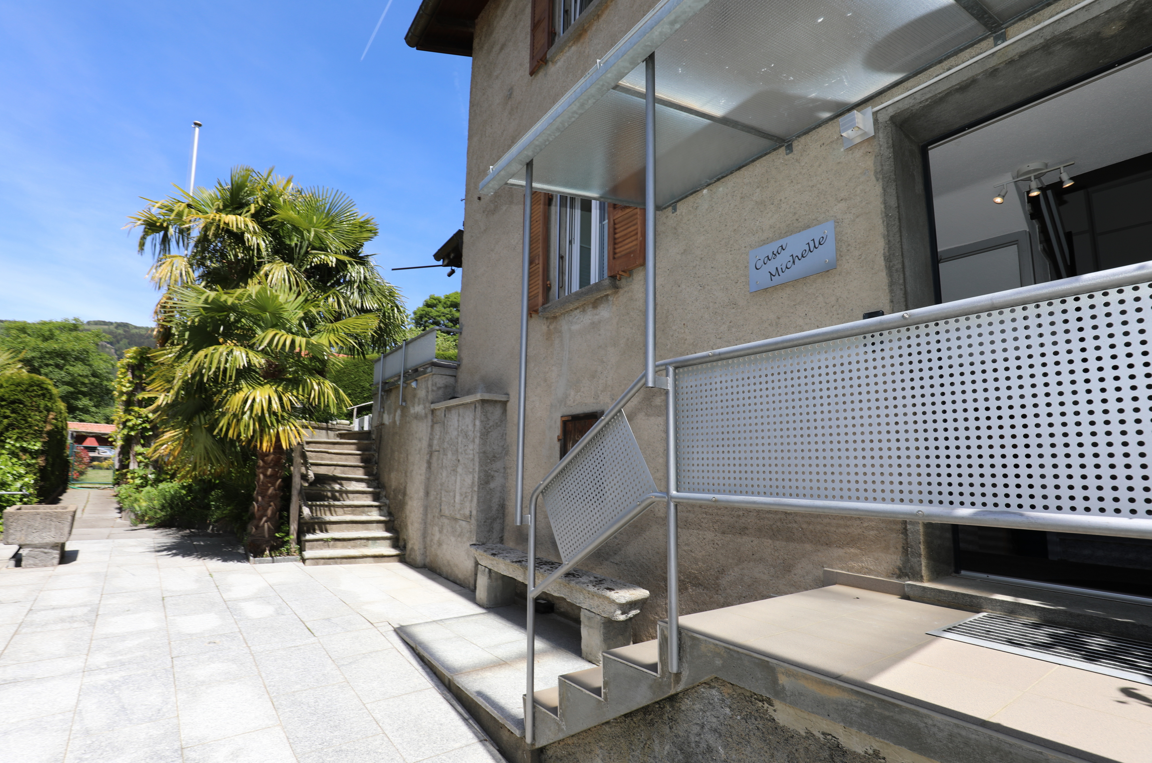 Außenansicht eines Hauses mit Eingangstreppe und Terrasse