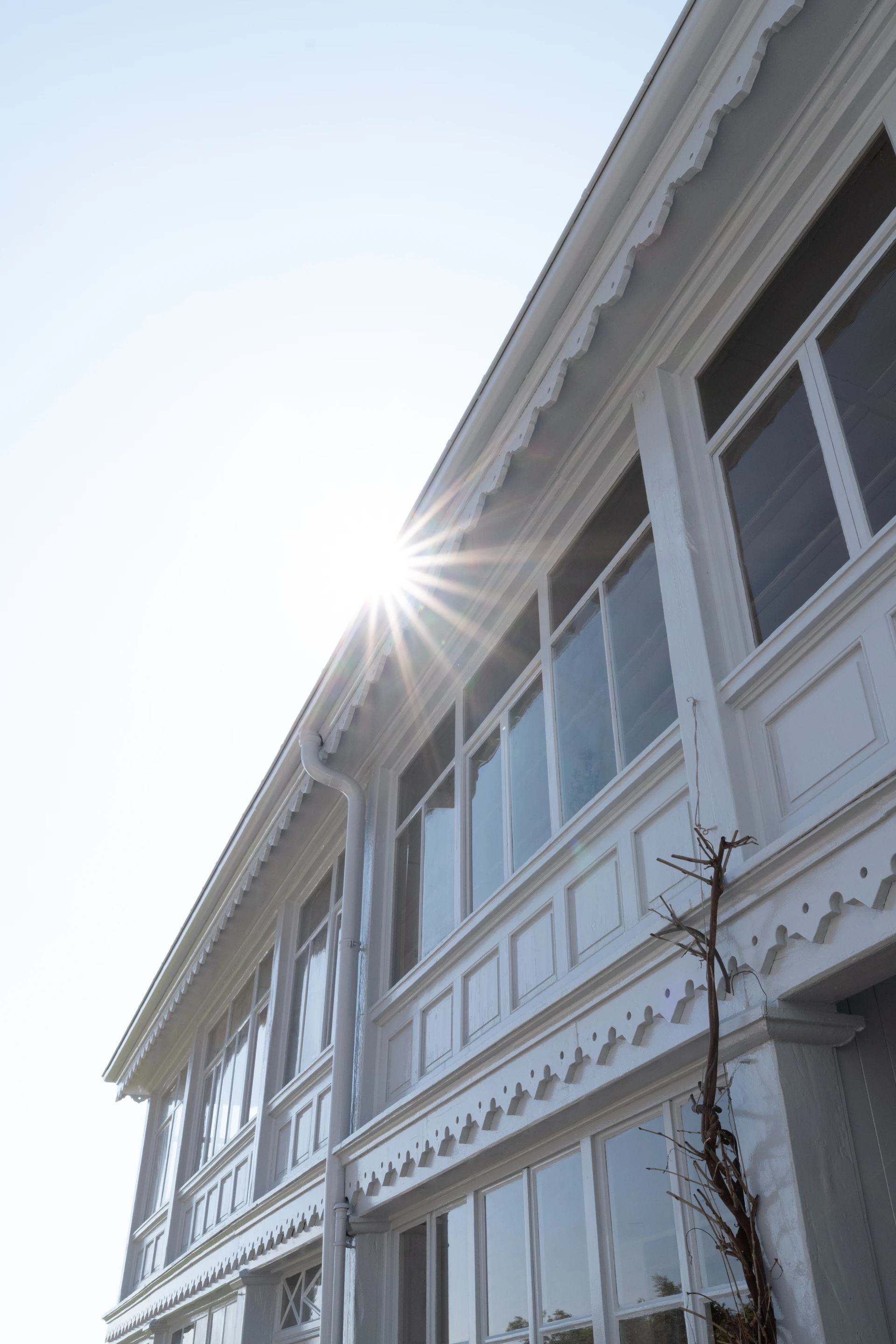 Weiße Fassade eines historischen Hauses mit hohen Fenstern