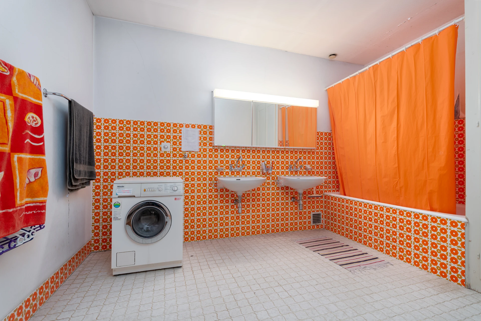 Wasch- und Badezimmer mit Waschmaschine und Doppelwaschbecken