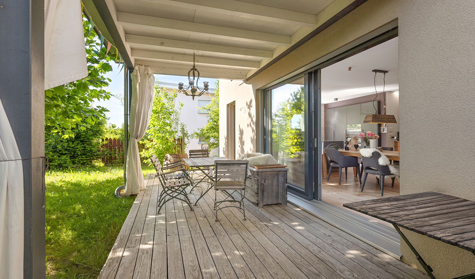 Überdachte Holzterrasse mit Blick in den Garten