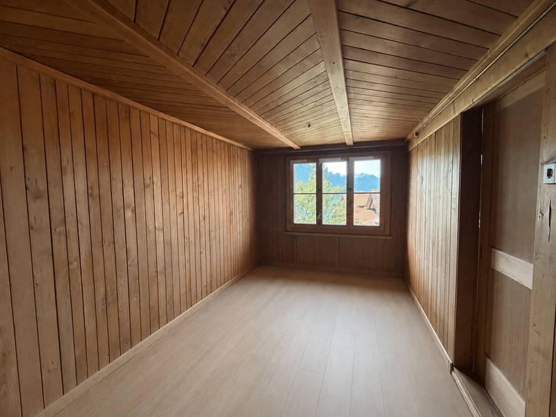 Holzvertäkelter Raum mit Fenster und Bergblick