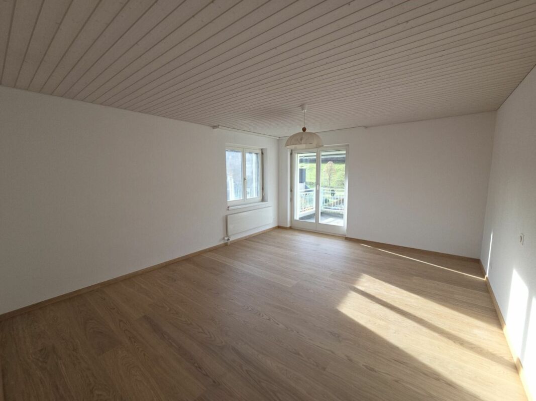 Leerer heller Wohnraum mit Balkonzugang