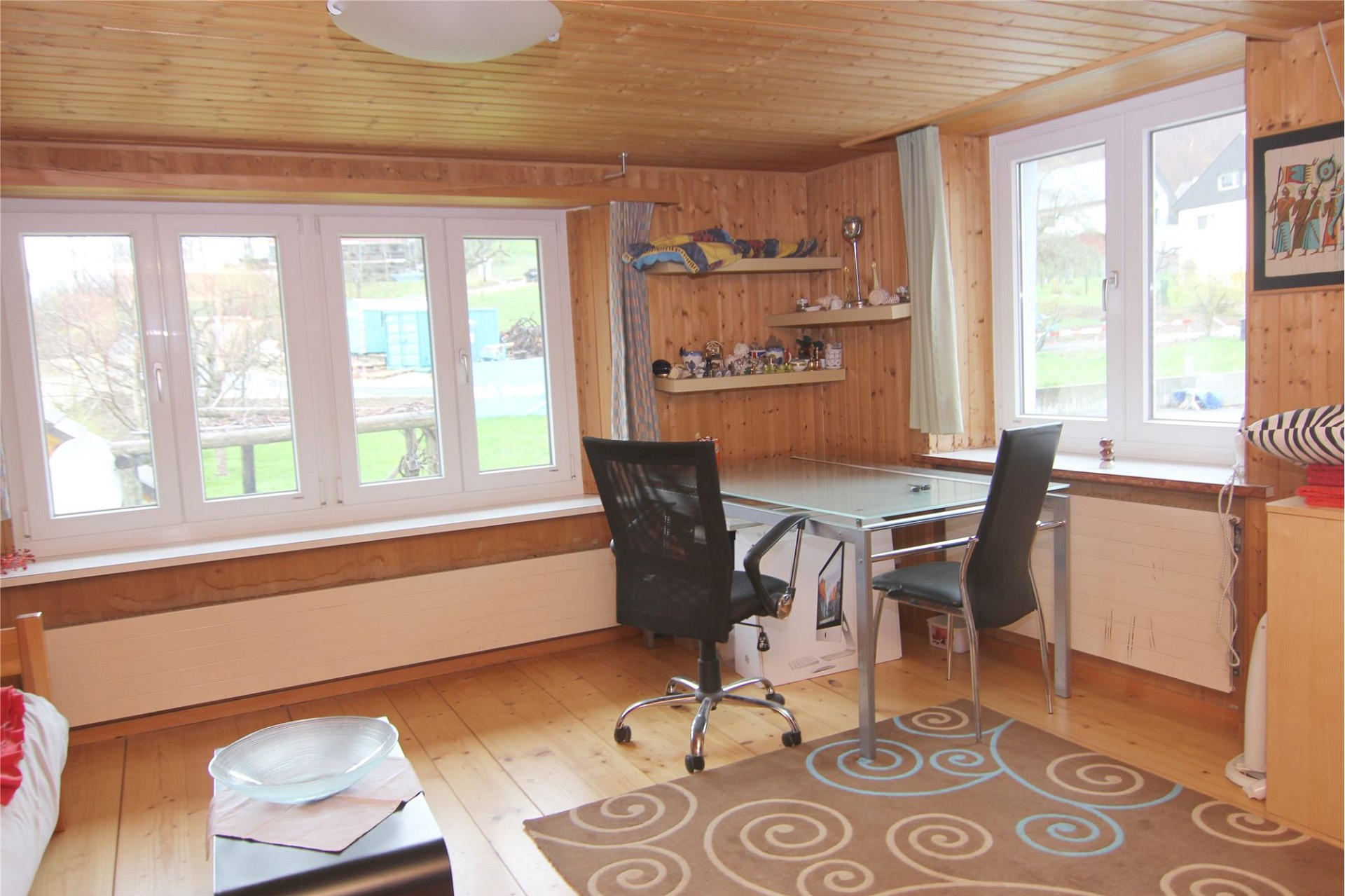 Gemütliches Holzraum-Büro mit großen Fenstern
