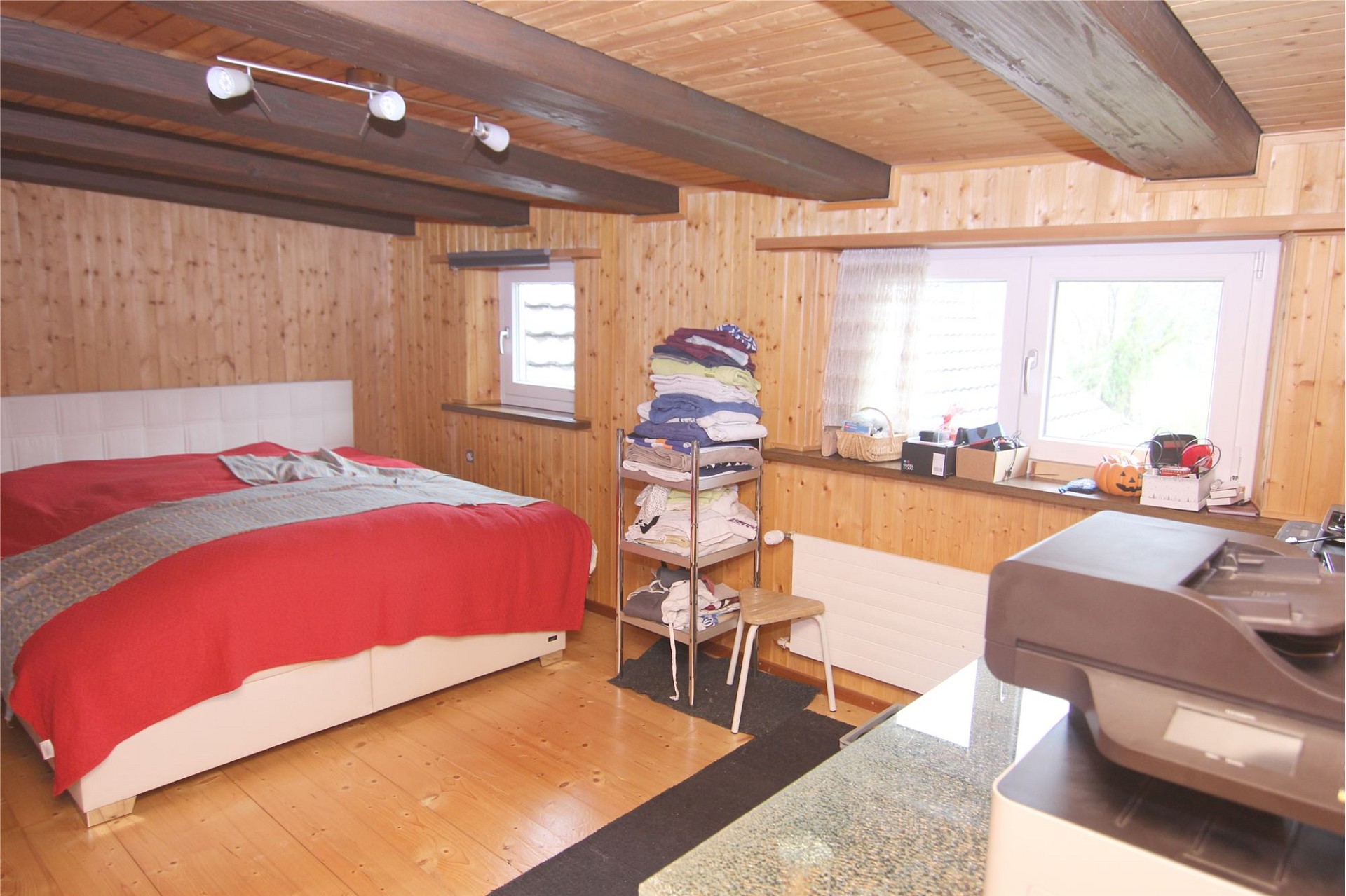 Holzverkleidetes Schlafzimmer mit Dachbalken
