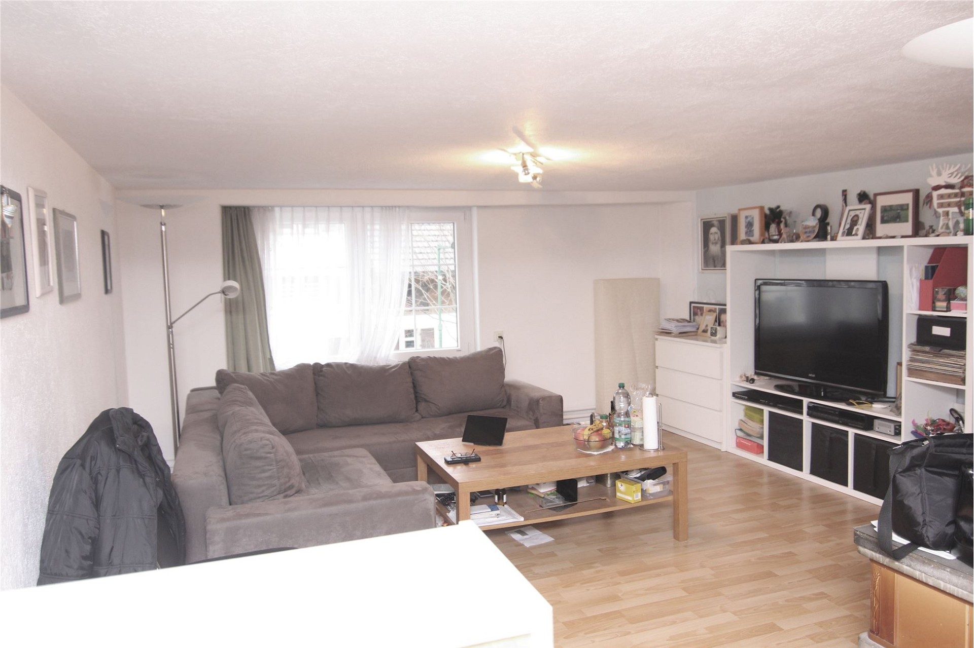 Wohnzimmer mit Sofa und TV-Wand
