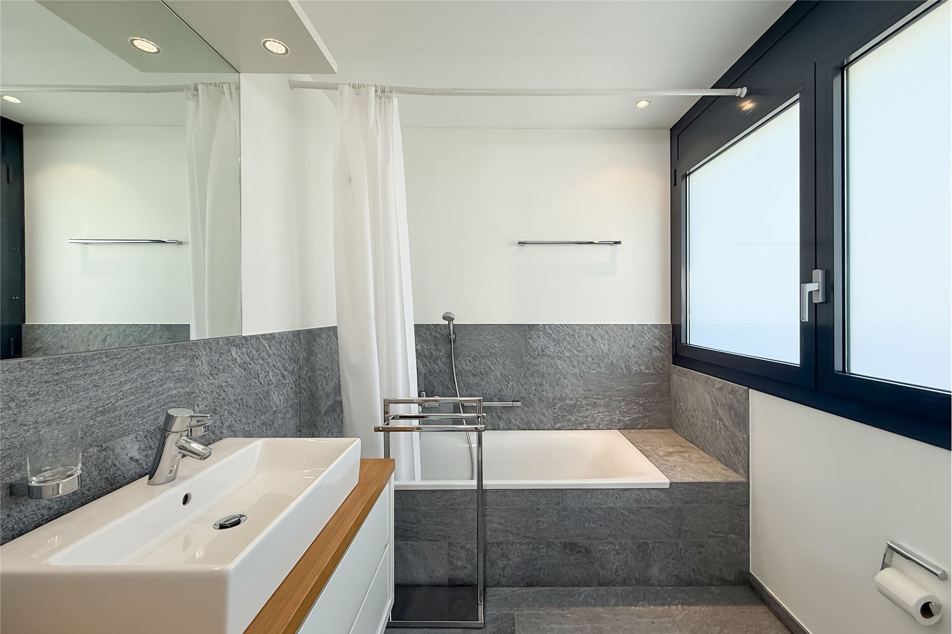 Modernes Badezimmer mit Badewanne und Fenster