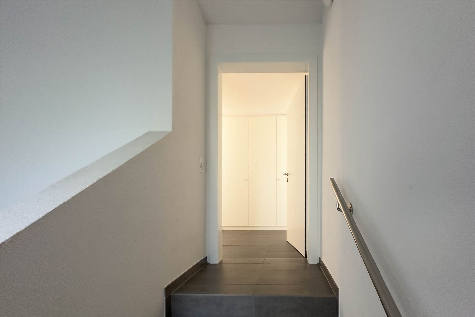 Heller Treppenflur mit Durchgang zu einem Einbauschrank