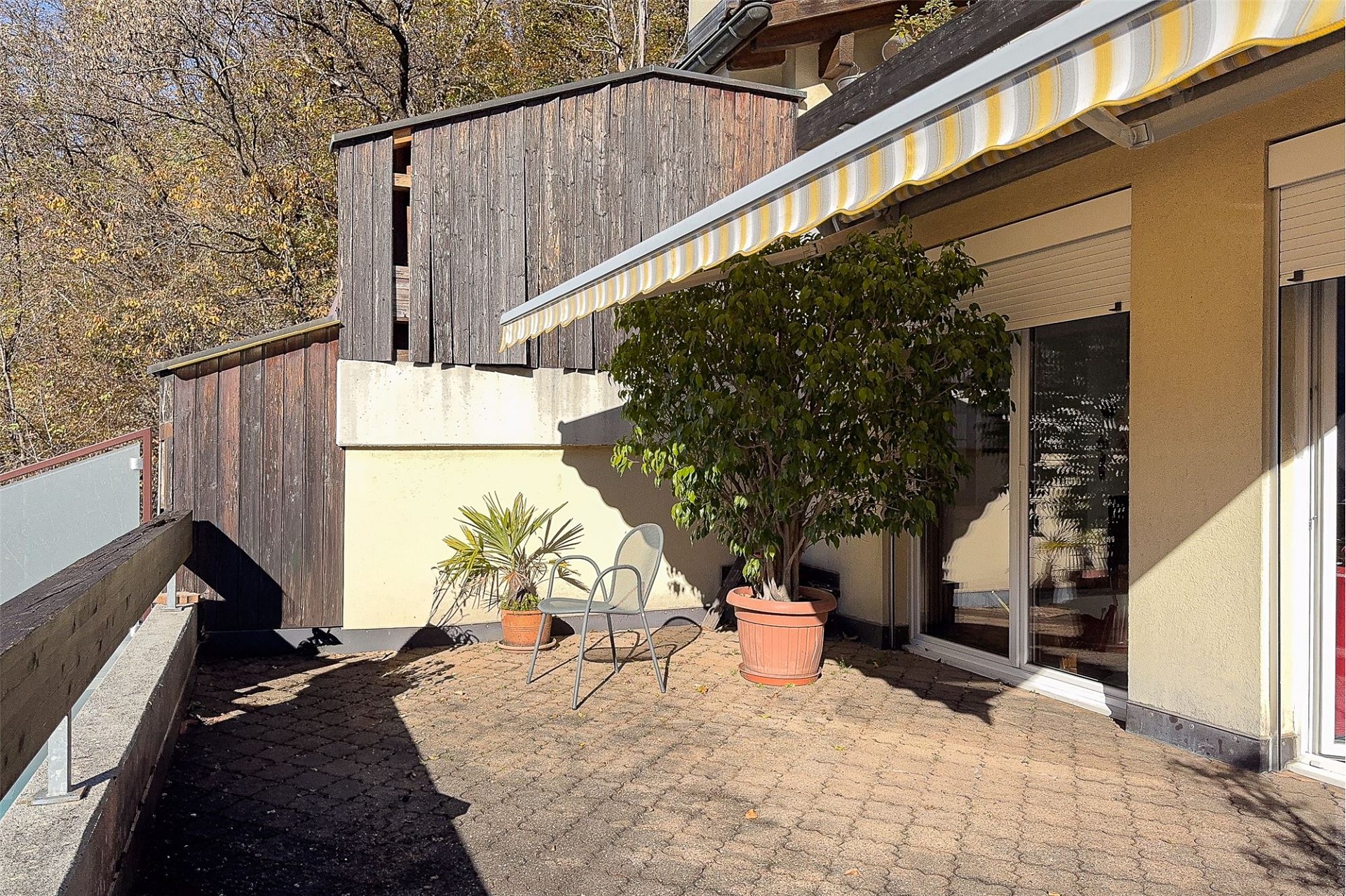 Terrasse mit Markise und Holzfassade