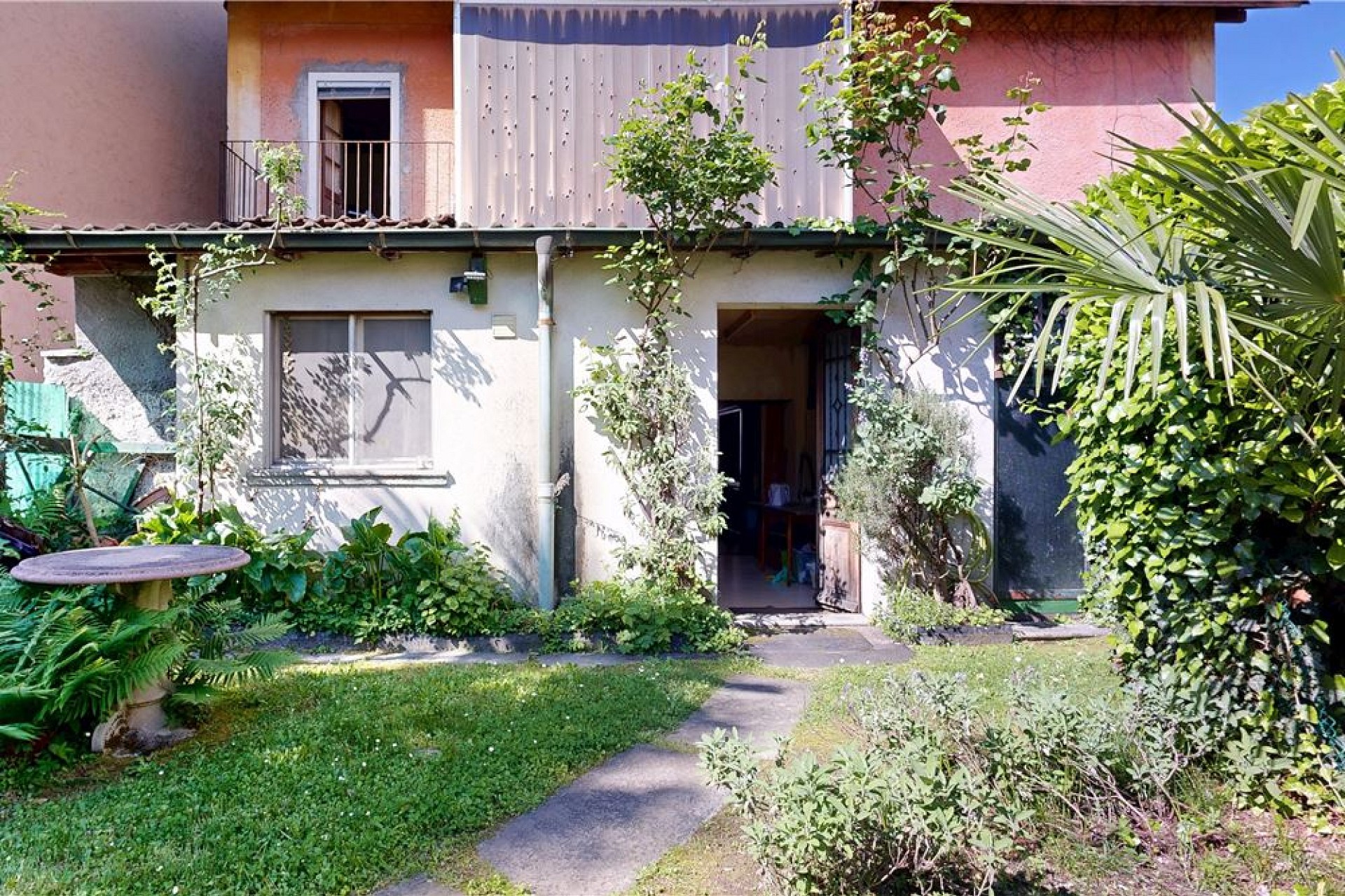 Gartenansicht eines Wohnhauses mit Terrasse und Balkonen