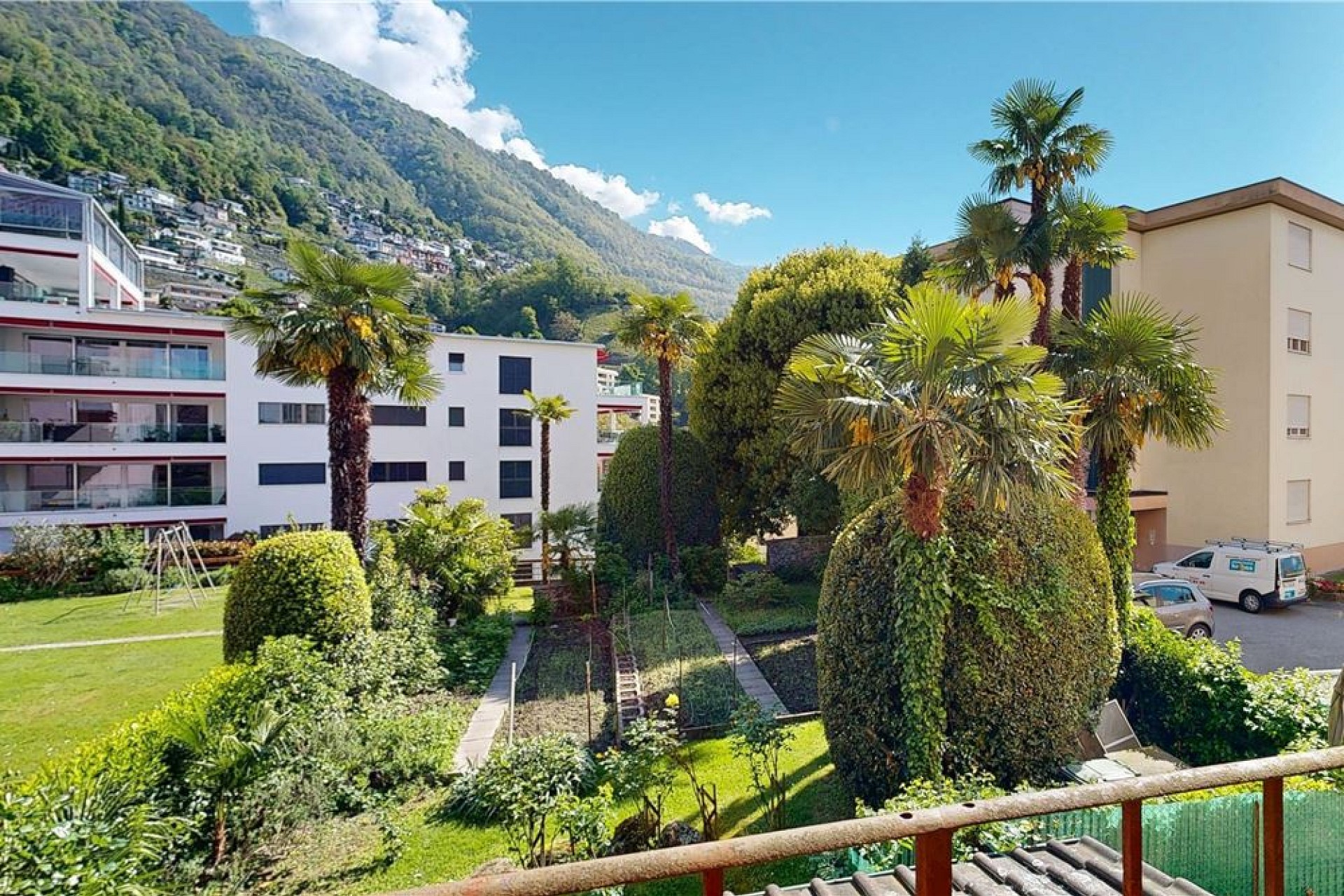 Blick auf mediterran wirkende Wohnanlage mit Garten