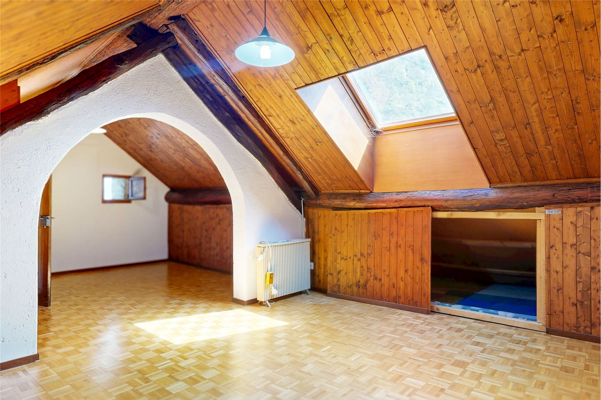 Dachgeschosszimmer mit Holzvertäfelung und Dachfenster
