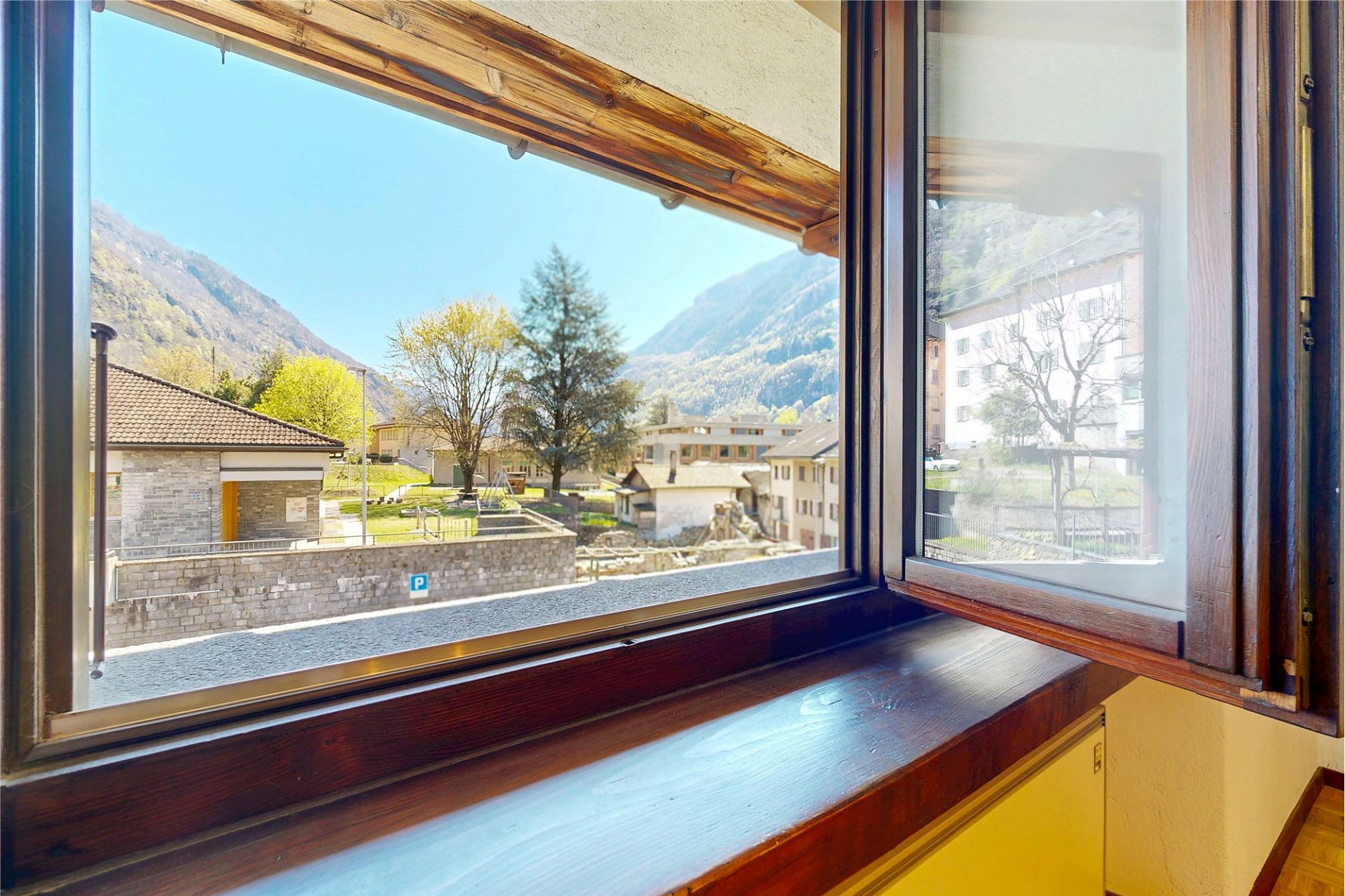 Blick aus einem geöffneten Fenster mit Bergpanorama