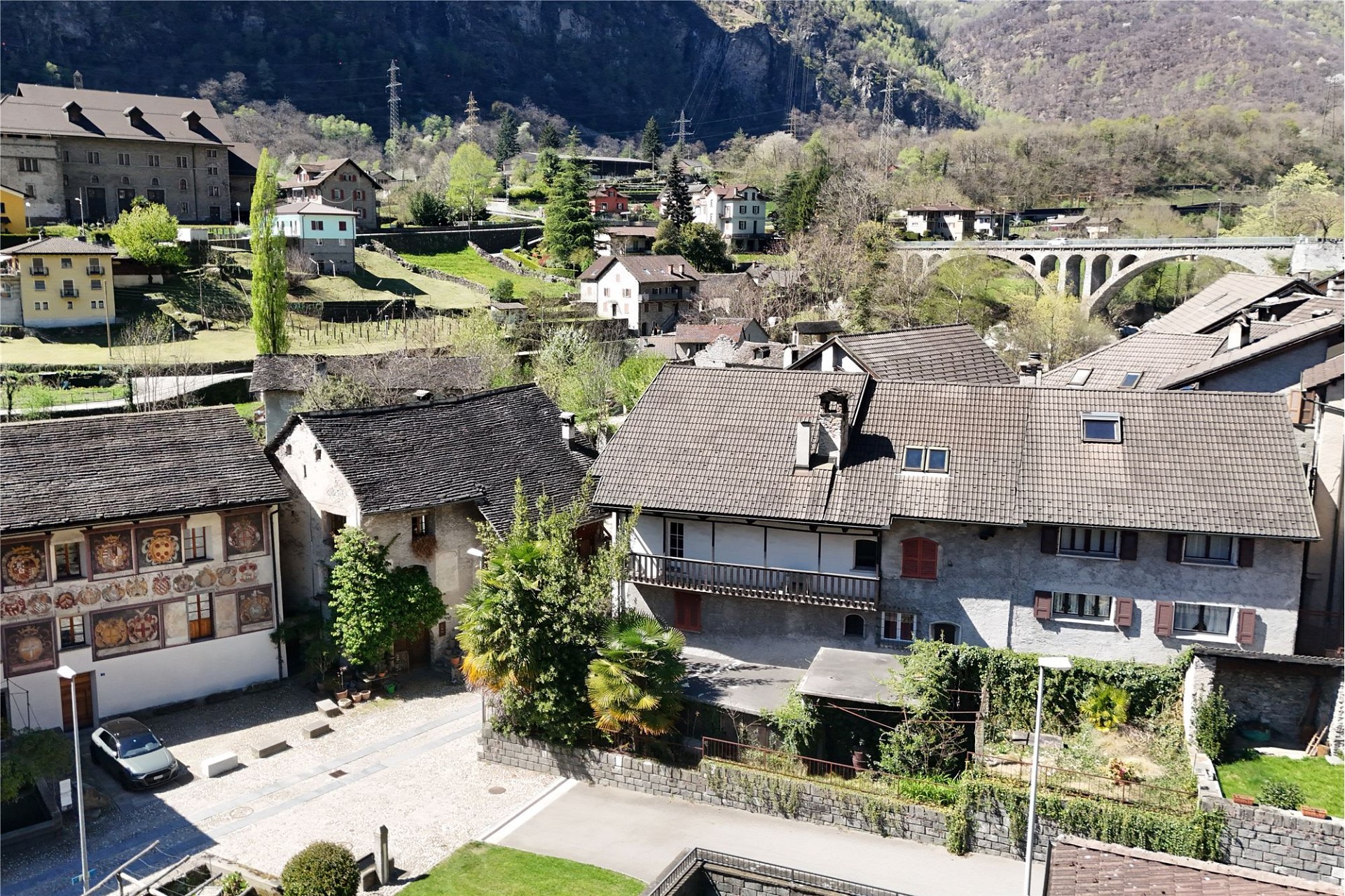 Blick auf ein alpines Dorf mit historischen Gebäuden und Viadukt