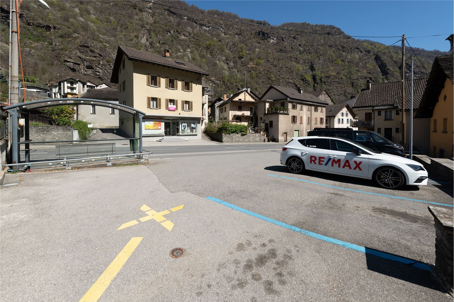 Außenansicht eines Dorfplatzes mit Häusern und Bergkulisse