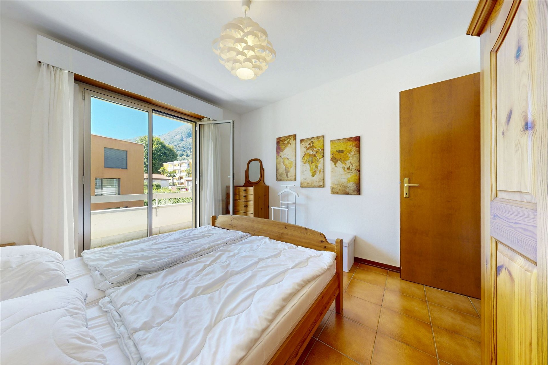 Helles Schlafzimmer mit Balkon und Bergblick