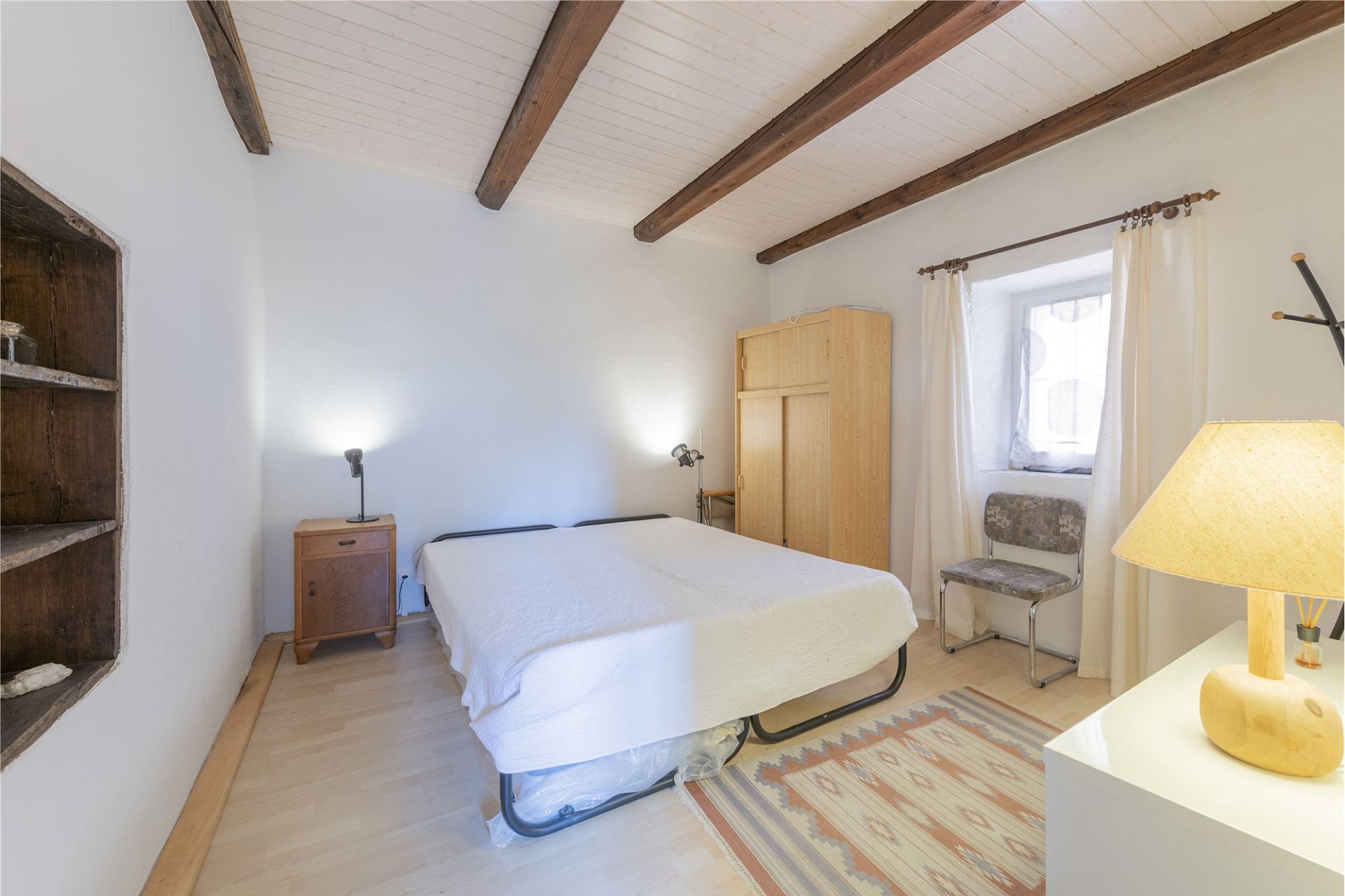 Helles Schlafzimmer mit Holzdeckenbalken