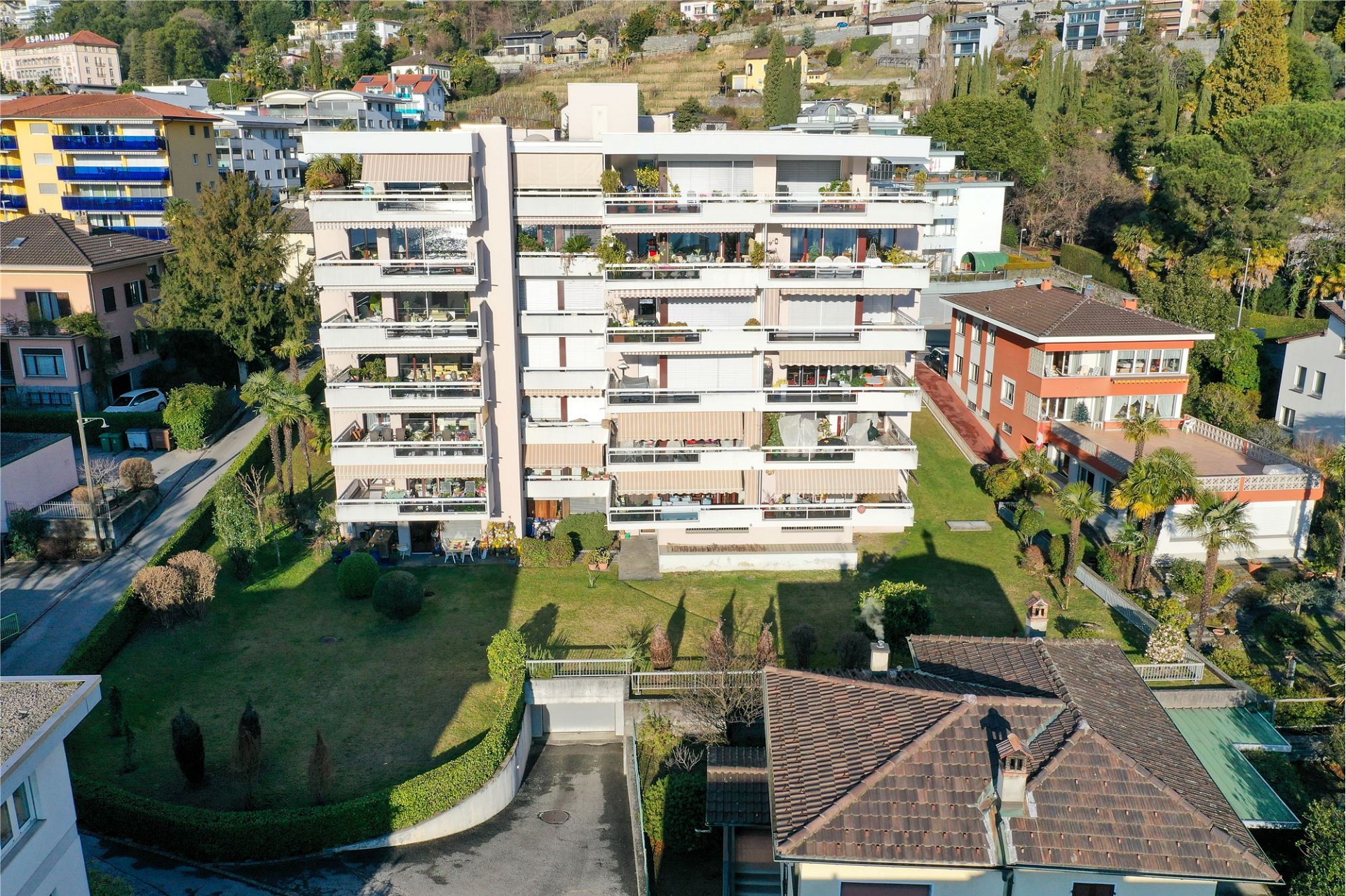 Luftaufnahme eines Mehrfamilienhauses mit Gärten