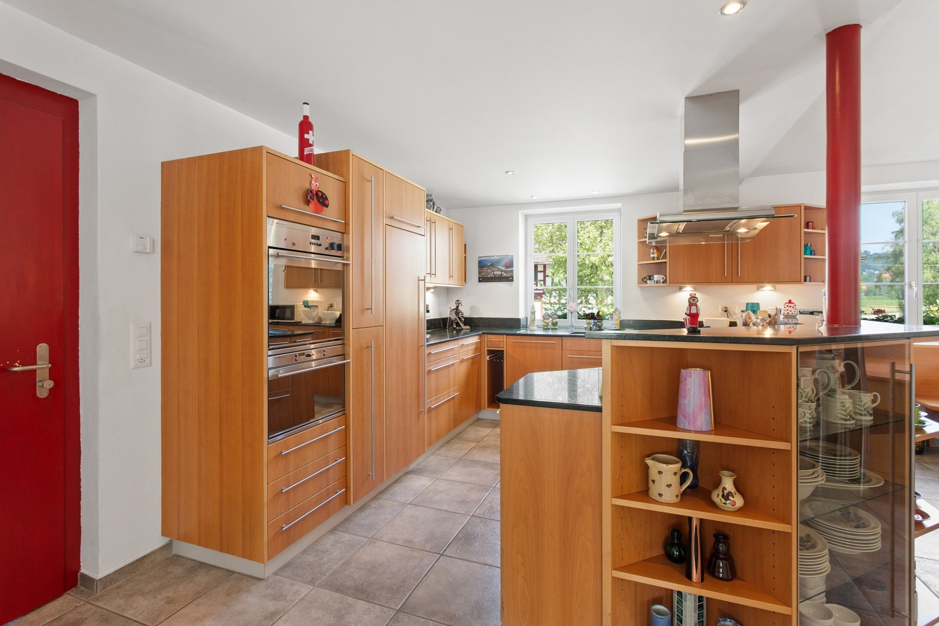 Moderne Küche mit Holzfronten und roter Tür