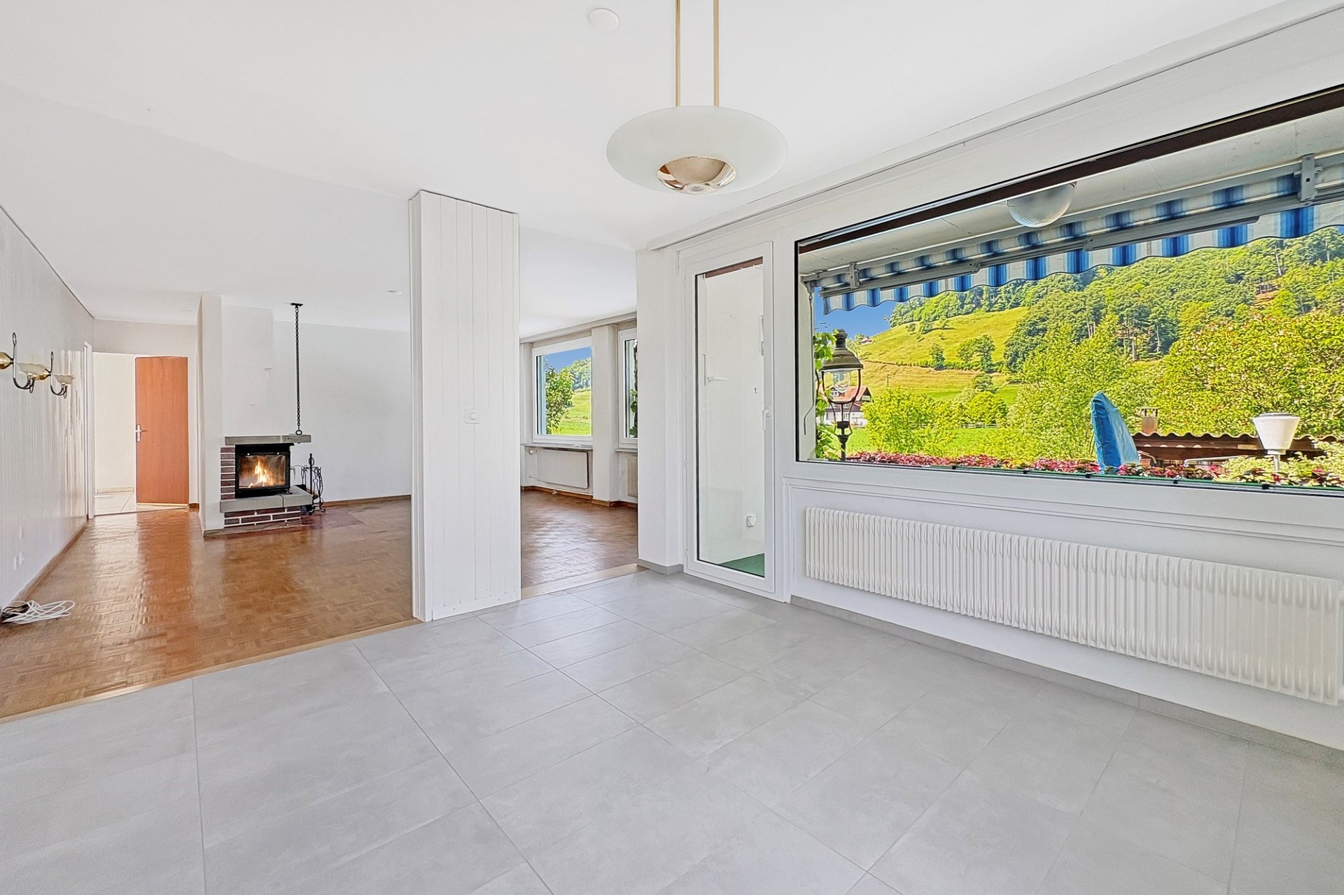 Heller Wohnraum mit Panoramafenster und Kamin