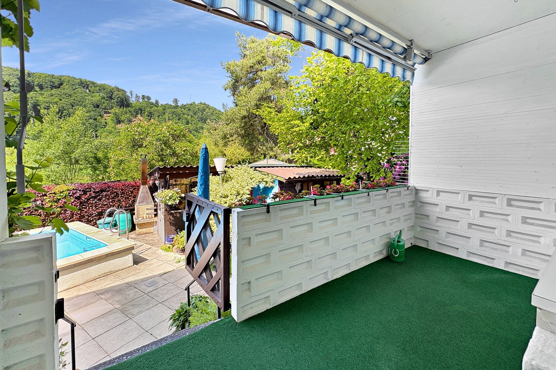 Überdachte Terrasse mit Poolblick