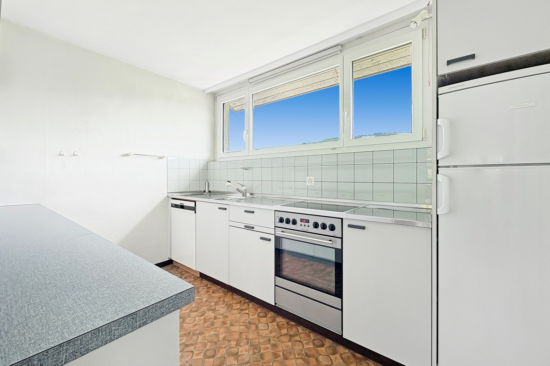 Helle Küche mit Fenster und Blick ins Freie