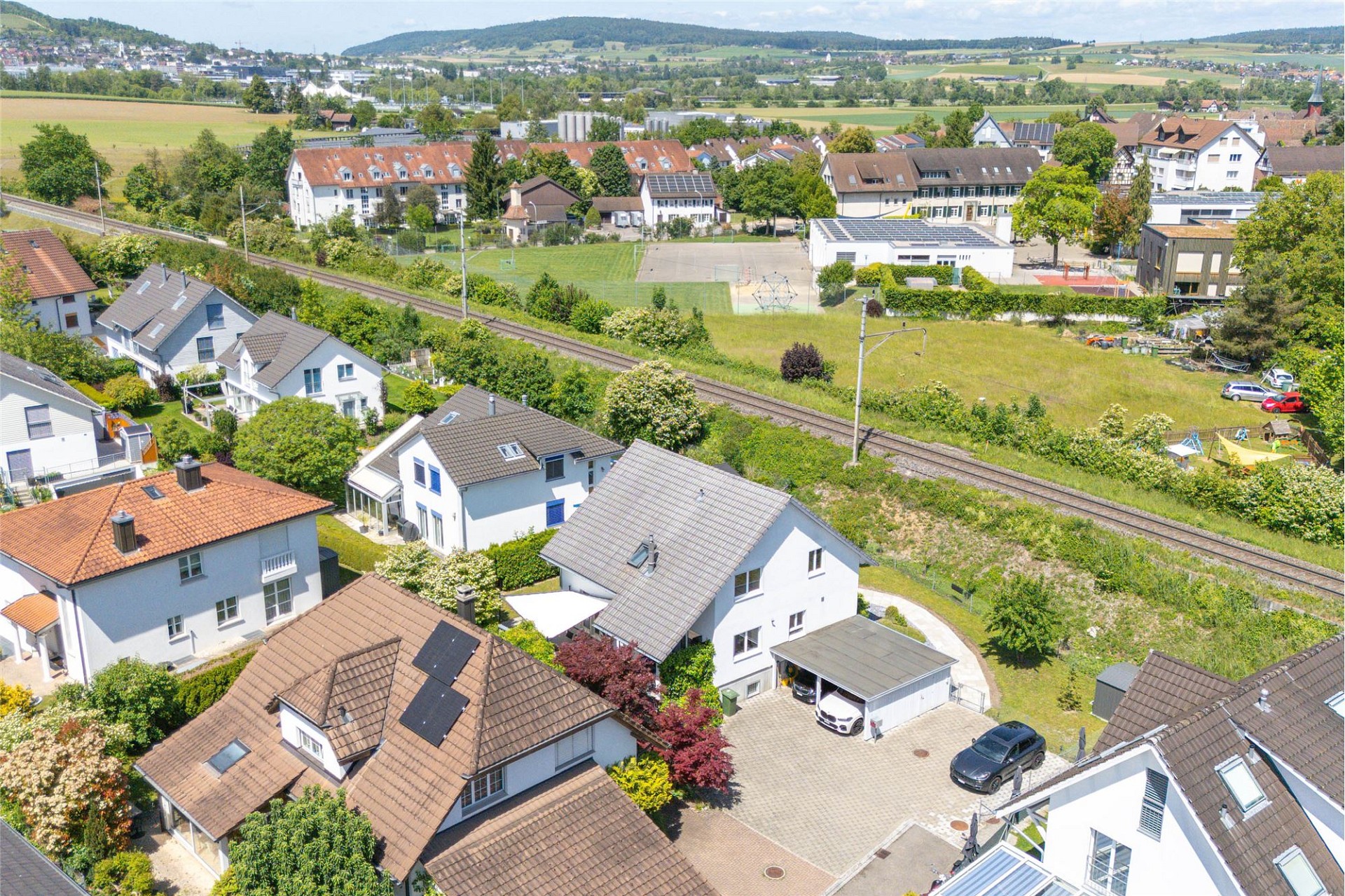 Luftaufnahme eines Wohngebiets mit Häusern und Bahntrasse