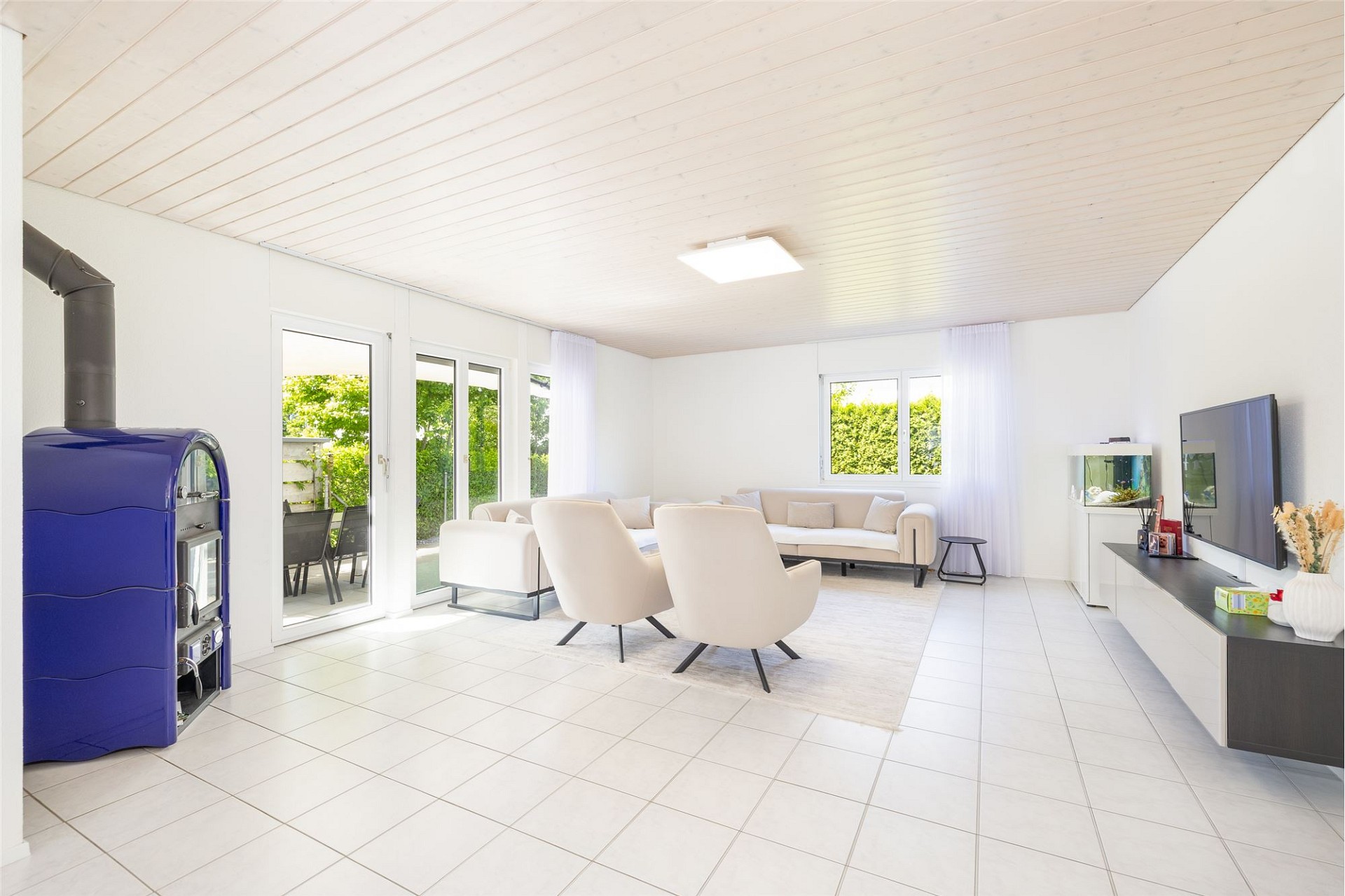 Heller Wohnraum mit Ofen und Terrasse