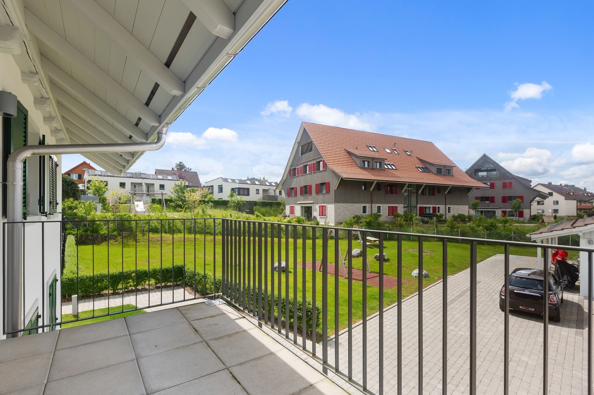 Balkon mit Blick auf Wohnanlage und Grünfläche