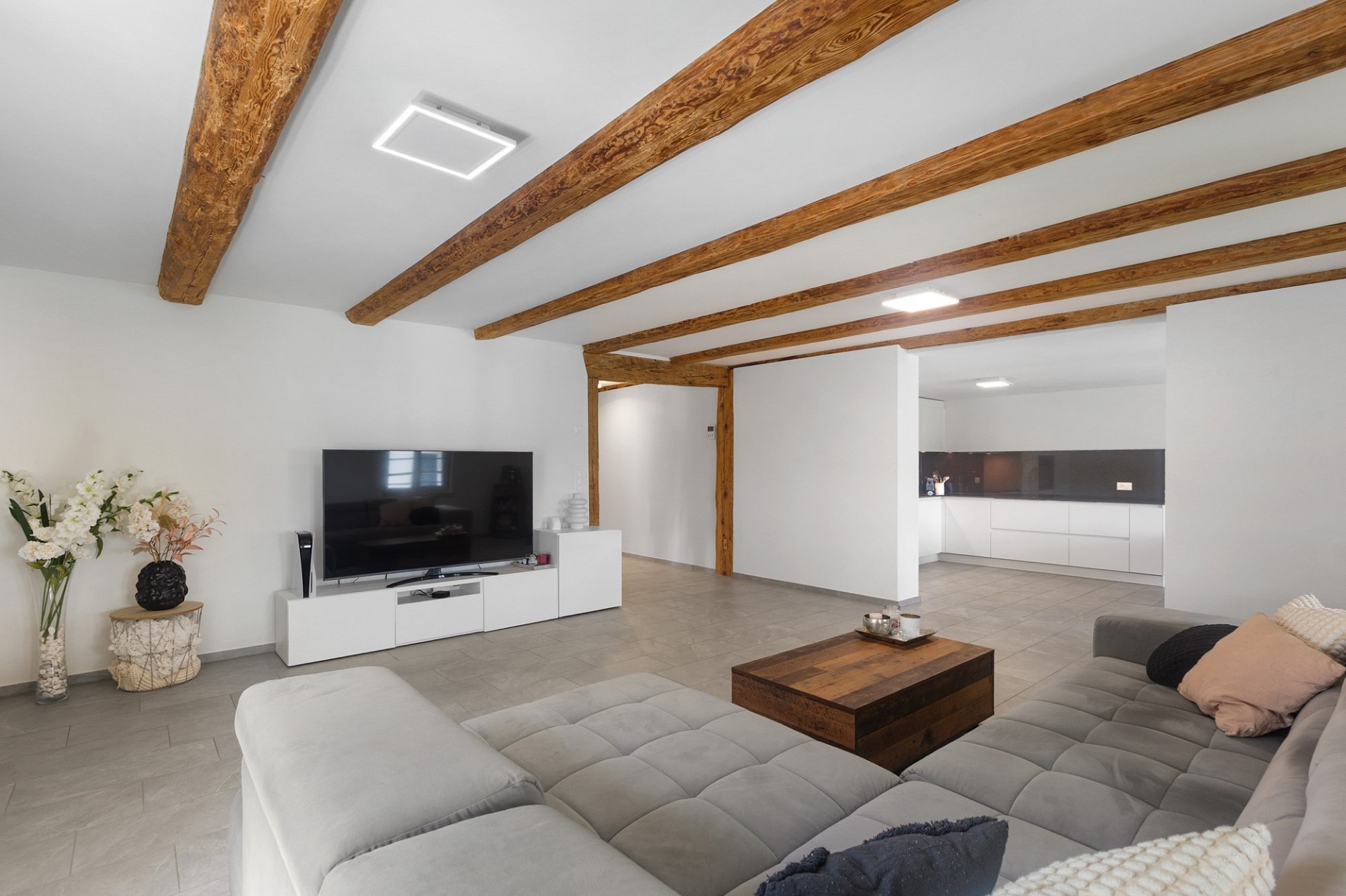 Offener Wohnraum mit sichtbaren Holzbalken